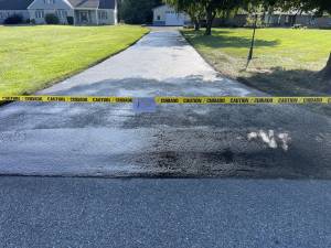 Caution tape marking off asphalt driveway